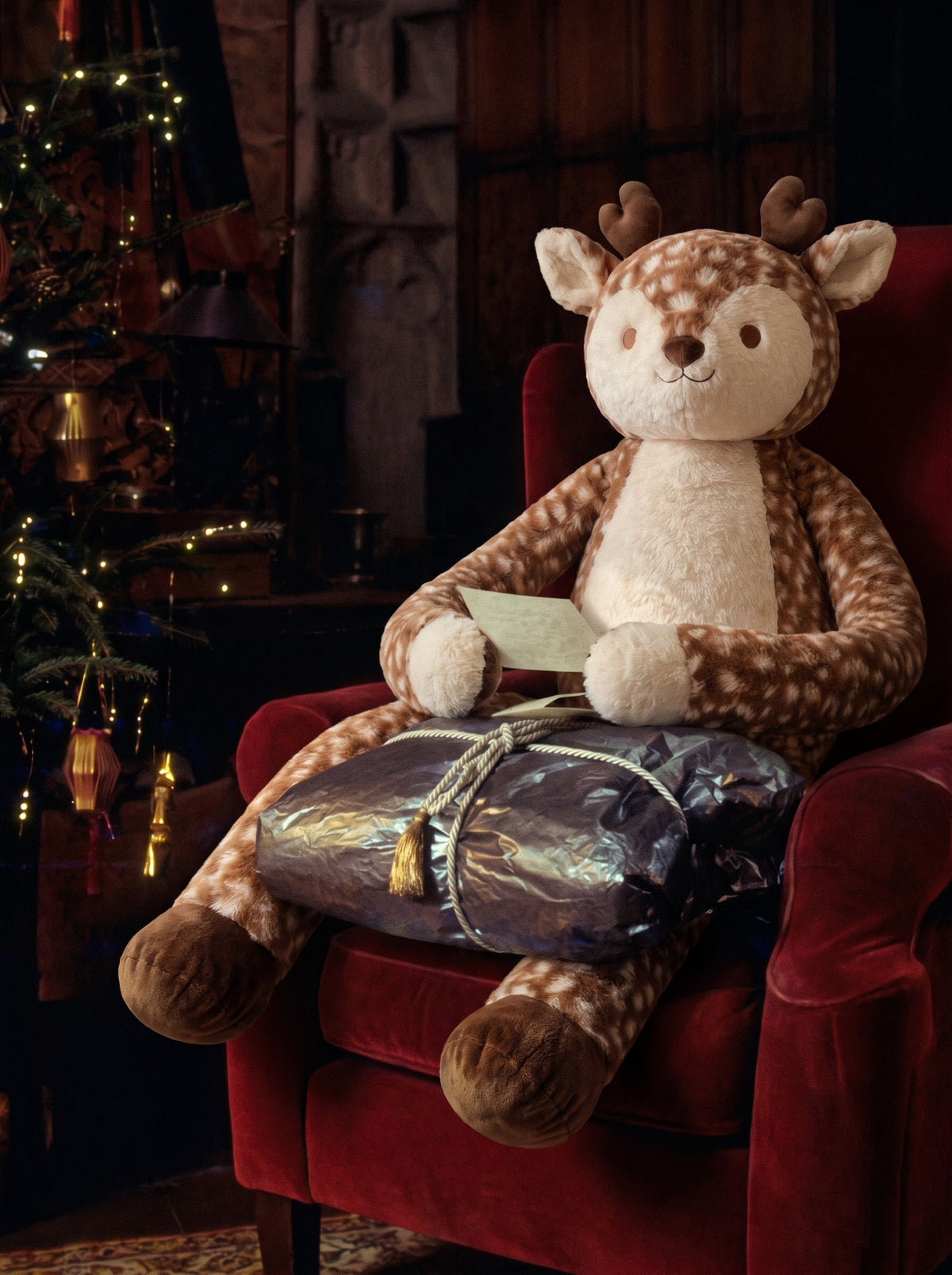 CLOUDFEL beside a Christmas tree with a wrapped gift