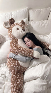 A person cuddling oversized Cloudfell in bed, showing its full-body proportions